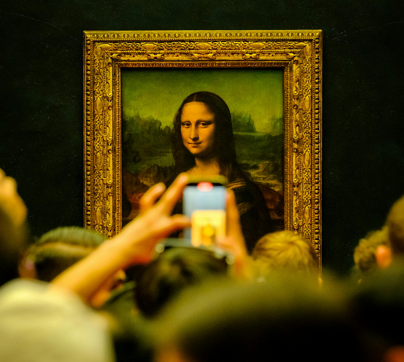 Image of a crowd of people viewing the Mona Lisa, within a gallery space.